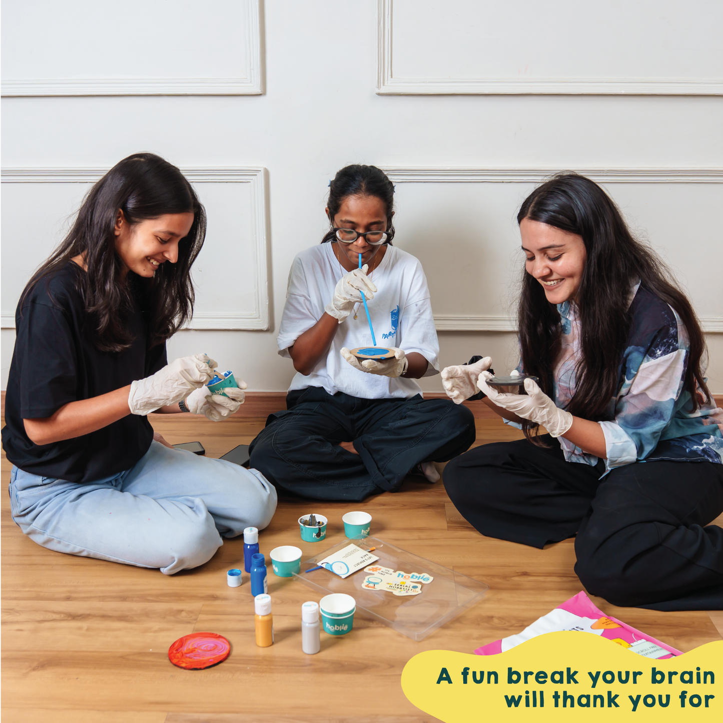 people having fun while doing fluid painting on coasters